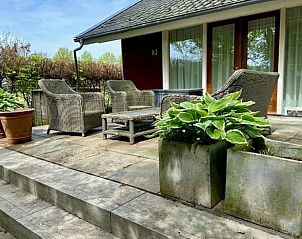 Buitenterras met planten bij Vakantiehuis in Angerlo, Rivierengebied, ideaal voor ontspanning.