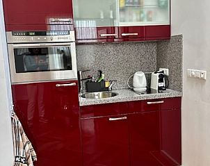 Compacte keuken in Vakantiehuis in Angerlo, Gelderland met stijlvolle rode kasten.