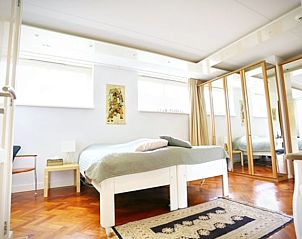 Ruime slaapkamer in Vakantiehuis in Angerlo, Gelderland met houten vloer en veel opbergruimte.