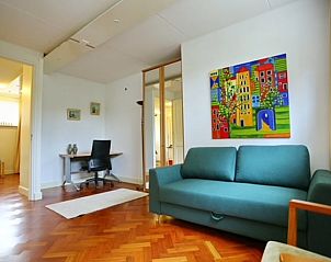 Studeerkamer in Vakantiehuis in Angerlo, Gelderland met kleurrijke kunst en comfortabele bank.