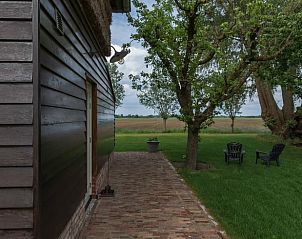 Rustieke veranda van vakantiehuisje in Beusichem, omgeven door bomen in Gelderland.