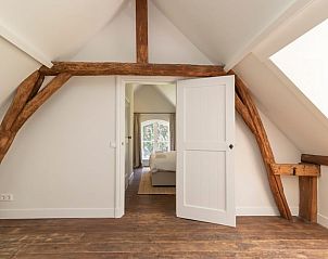 Slaapkamer met houten balken in Huisje in Kerk-Avezaath, Gelderland.