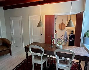 Eetkamer in Vakantiehuisje in Neerijnen, sfeervolle ruimte met houten tafel en landelijke inrichting in Rivierengebied.