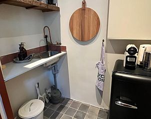 Compacte keuken in Vakantiehuisje in Neerijnen, Gelderland, voorzien van moderne apparatuur en praktische indeling.