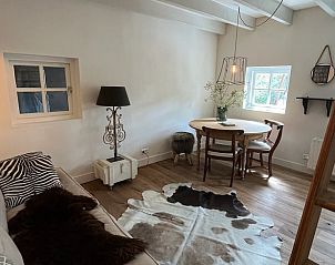 Knusse zithoek in Vakantiehuisje in Neerijnen, Gelderland met ronde tafel en sfeervolle lamp.