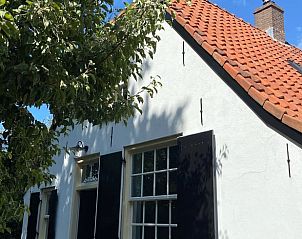 Charmant exterieur van Vakantiehuisje in Neerijnen, Gelderland met authentiek witgepleisterde muren.