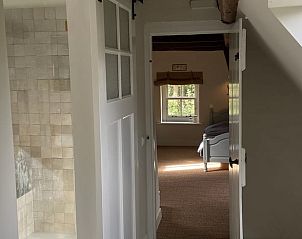 Lichte doorgang naar slaapkamer in vakantiehuisje in Neerijnen, met uitzicht op de tuin in het Rivierengebied.