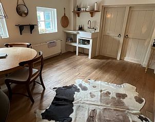 Eetruimte met houten vloer in vakantiehuisje in Neerijnen, gezellig voor familiediners in het Rivierengebied.