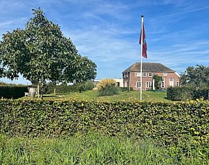 Vakantiehuis in Duiven, Gelderland met weelderige tuin en vlag, ideaal gelegen in het Rivierengebied voor een ontspannen verblijf.