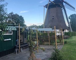 Geniet van de rust bij Huisje in Geldermalsen, een vakantiehuis in Gelderland, met uitzicht op een historische molen en groene omgeving.