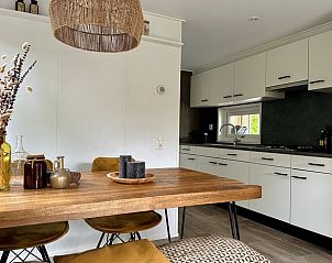 Gemtliche Kche und Essbereich in Cottage in Gellicum, Ferienhaus im Rivierengebied, Gelderland, mit einem rustikalen Holztisch und stilvoller Einrichtung.