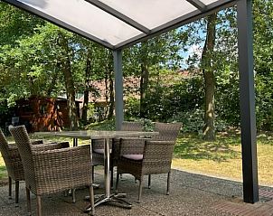 Enjoy the serene veranda at Cottage in Winterswijk, a vacation home in Achterhoek, Gelderland, surrounded by green nature.
