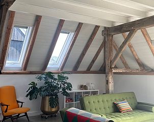 Cozy interior of Holiday Home in Winterswijk with wooden beams and lots of natural light.
