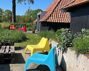 Terrace at Holiday Home in Winterswijk with colorful chairs and a relaxing outdoor environment.