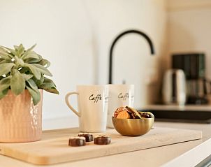 Detail van koffiemokken en lekkernijen in de keuken van Vakantiehuisje in Winterswijk.