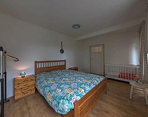 Cozy bedroom in Holiday Home in Winterswijk, Achterhoek with wooden furniture and colorful bedding.