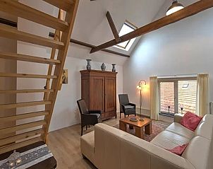 Cozy attic room in Holiday Home in Winterswijk with wooden beams and sitting area.