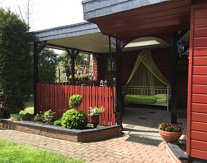 Entrance to Holiday Home in Winterswijk, Achterhoek, with charming porch and colorful flowers.