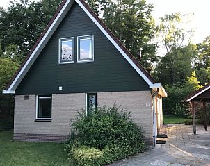 Rustic facade of Holiday Home in Winterswijk, Achterhoek, surrounded by lush trees and serene nature.
