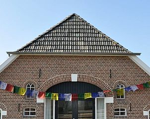 Traditionele architectuur van Vakantiehuisje in Barchem, Achterhoek, Gelderland, met kleurrijke vlaggen.