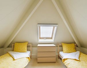 Tweepersoons slaapkamer met gele accenten in Huisje in Barchem, Achterhoek.