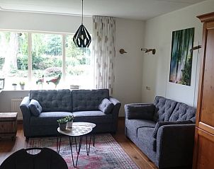 Gezellige woonkamer in Huisje in Barchem, vakantiehuis in de Achterhoek met comfortabele banken en uitzicht op de tuin.