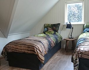 Gezellige slaapkamer in Huisje in Barchem, vakantiehuis in Gelderland, met twee eenpersoonsbedden en houten interieur.
