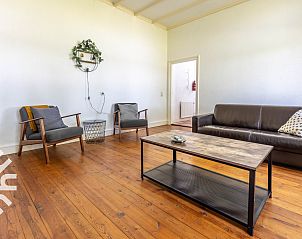 Comfortabele zithoek in vakantiehuis DG693, Barchem, met houten vloer en decoraties.