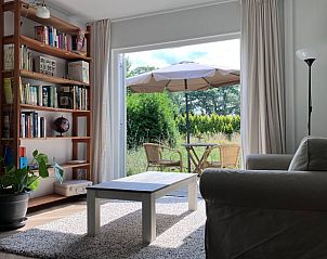 Lichte woonkamer van vakantiehuisje in Barchem met openslaande deuren naar het terras in Gelderland.