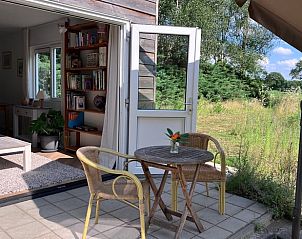 Zonnig terras van vakantiehuisje in Barchem met zitje en uitzicht op de natuur in Gelderland.