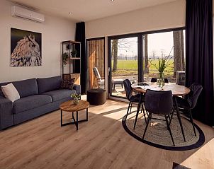 Lichte woonkamer van Vakantievilla Amalia 2 in Kotten, met uitzicht op de velden.