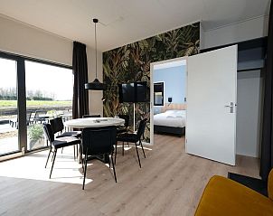 Eetkamer met uitzicht in Amalia Familia vakantiehuis, Kotten, Achterhoek met toegang tot slaapkamer.