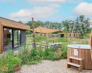 Buitenzitje bij Parklodge 6 in Kotten: vakantiehuis met hottub en sauna in de tuin.