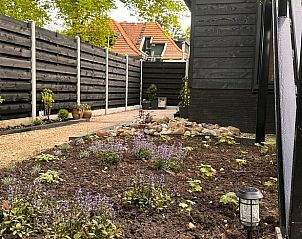 Tuin van Vakantiehuis in Rekken met bloembedden en privacy in de Achterhoek, Gelderland.