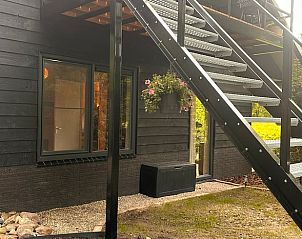 Trap naar het terras van Vakantiehuisje in Rekken, omgeven door groen in Achterhoek, Gelderland.