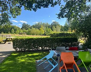 Terras van Huisje in Heelweg met kleurrijke stoelen en uitzicht op de natuur in Achterhoek, Gelderland.