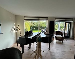 Ruime woonkamer met piano en veel lichtinval in Vakantiehuis in Heelweg, Achterhoek, Gelderland.