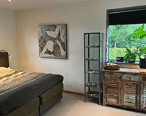 Stijlvolle slaapkamer met kunst aan de muur in Vakantiehuis in Heelweg, Achterhoek, Gelderland.