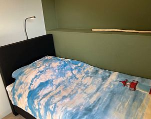 Eenpersoonsbed met kleurrijk dekbedovertrek in Vakantiehuis in Heelweg, Achterhoek, Gelderland.