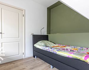 Zithoek in DG1611 vakantiehuis Heelweg, Achterhoek met kleurrijke stoelen en planten.