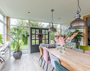 Eetkamer met uitzicht op tuin in DG1611 vakantiehuis Heelweg, Achterhoek met grote tafel.