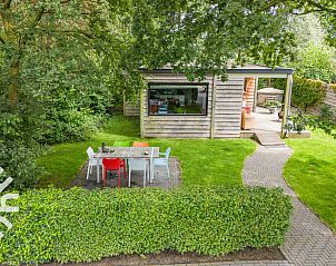 Woonkamer met rode stoelen in vakantiehuis DG411 in Heelweg, Achterhoek.