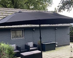 Ruim terras met parasol bij Vakantiehuis in Zelhem, Achterhoek, Gelderland voor ontspanning in de buitenlucht.