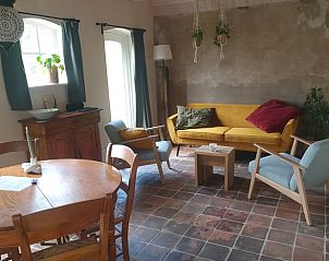 Knusse zithoek in Huisje in Zelhem, vakantieaccommodatie in Zelhem met een stijlvolle bank en veel natuurlijk licht.