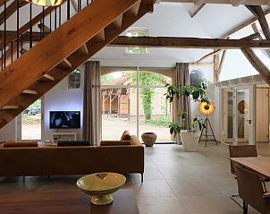 Ruime woonkamer in Vakantiehuisje in Zelhem, Achterhoek, Gelderland, met moderne inrichting en uitzicht op de tuin.