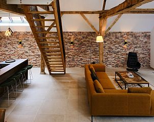 Gezellige binnenruimte van Vakantiehuisje in Zelhem, Achterhoek. Moderne woonkamer met houten balken en comfortabele zitgelegenheid.