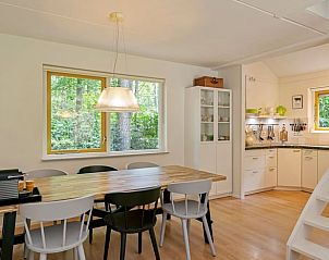 Gezellige eetkamer in Vakantiehuis in Zelhem, Achterhoek, Gelderland met uitzicht op groene omgeving en moderne keuken.