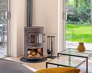 Gezellige binnenruimte van Vakantiehuis in Zelhem, gelegen in de Achterhoek, met houtkachel en uitzicht op groene tuin in Gelderland.