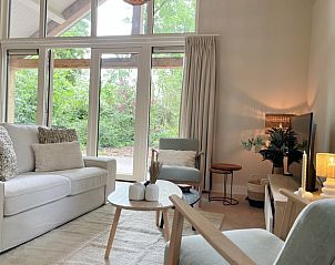 Gezellige woonkamer van Huisje in Ruurlo, vakantiehuis in de Achterhoek, Gelderland, met grote ramen en uitzicht op groene natuur.