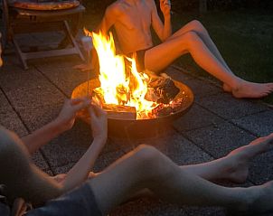 Kinderen genieten van een kampvuuravond bij Vakantiehuis in Aalten, een gezellige sfeer in Gelderland.